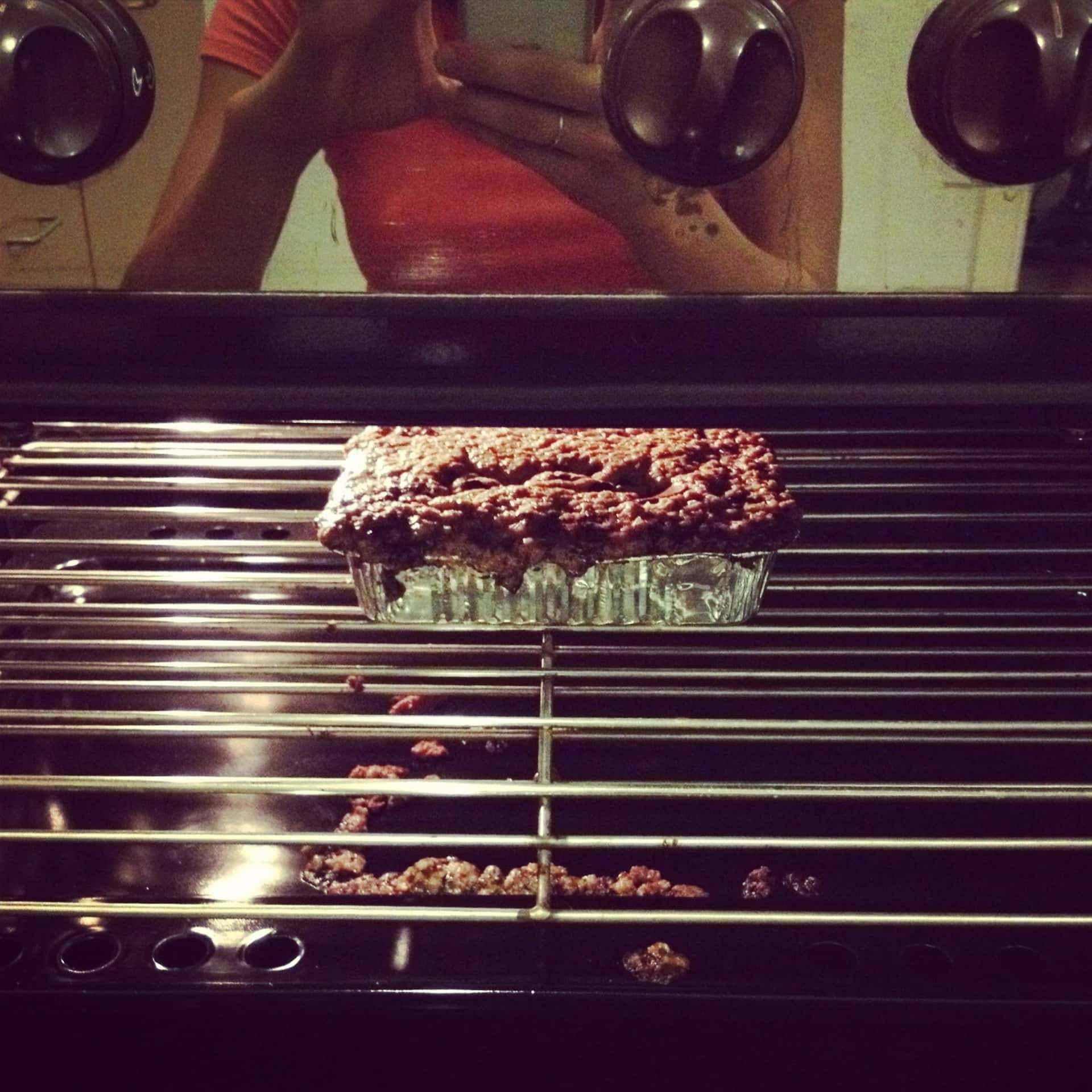 A tin on a grill overflowing with cake batter.