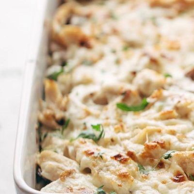 Chicken Tetrazzini baked in a pan with wooden spoon.