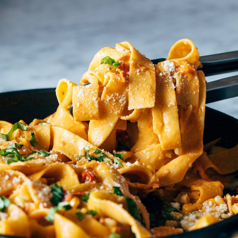 A picture of Burst Tomato Pappardelle with Zucchini, Sweet Corn, and Pan-Fried Chicken