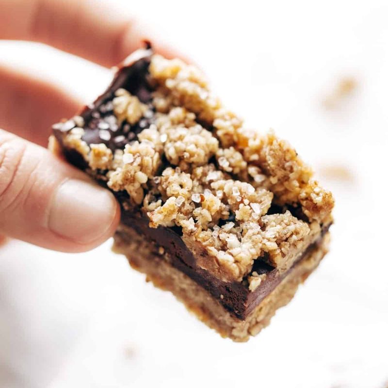 Salted chocolate snack bar held by a hand.