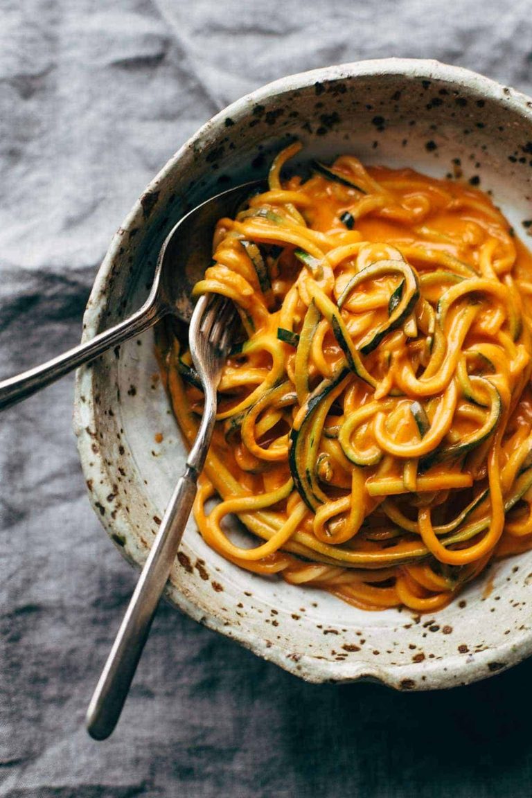Roasted red pepper pasta in a bowl with zucchini noodles.