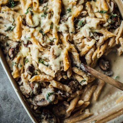 Mushroom Alfredo Pasta Bake in a pan with a spoon.